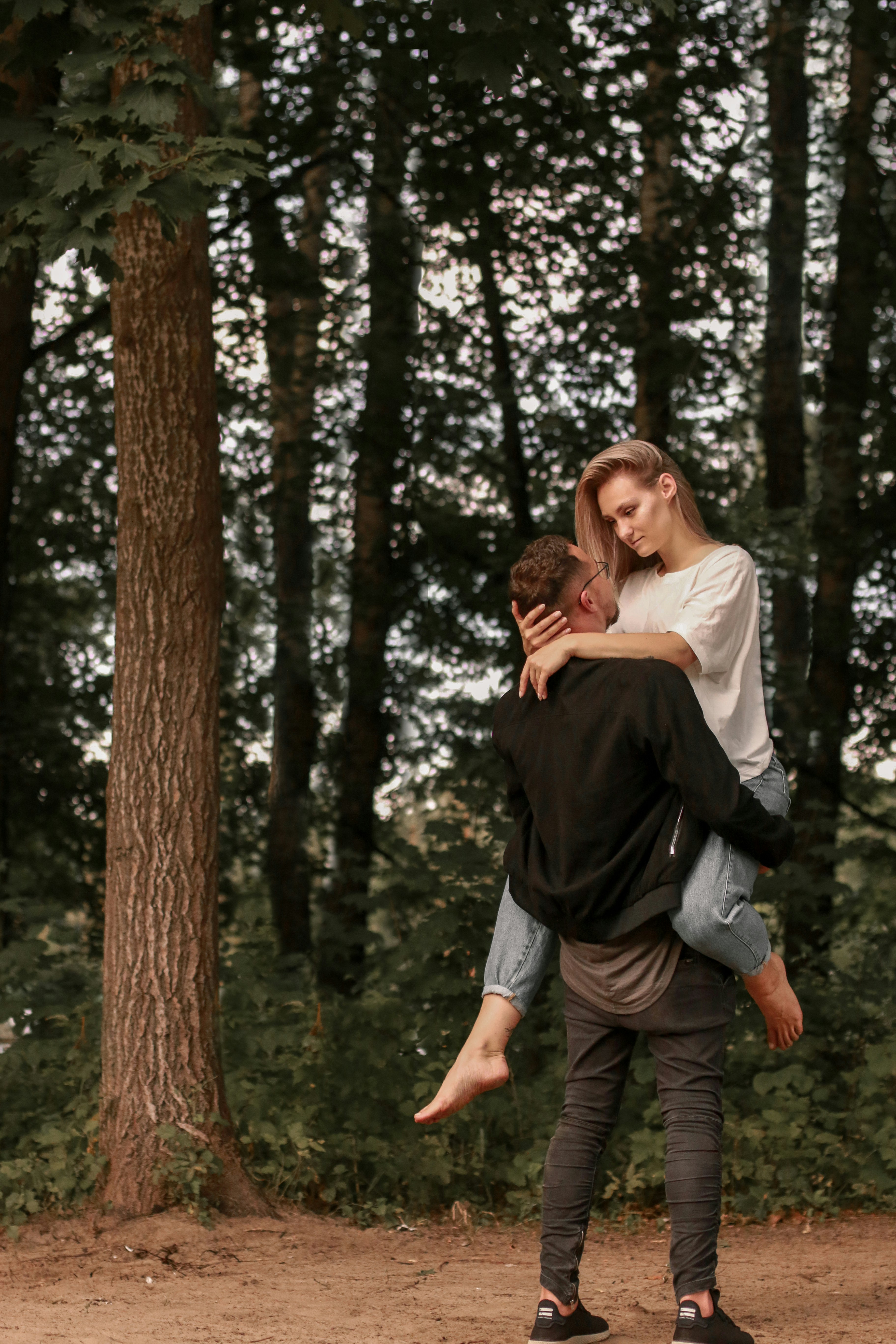 woman in black jacket carrying woman in white sweater